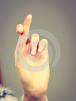 Woman hand crossing fingers, making promise gesture