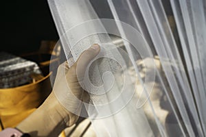 Woman hand on the curtain