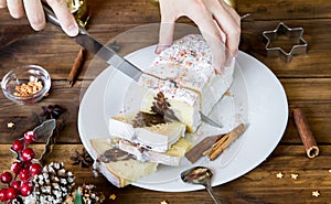 Woman hand cut christmas chocolate cake with holiday decoration. Food xmas background.