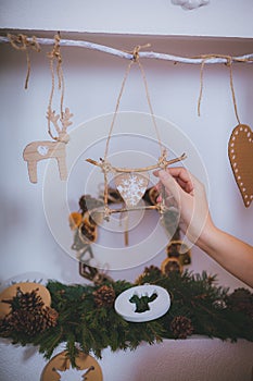 Woman hand decorating a Christmas tree toys