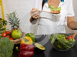 woman hand eating salad in bowl which she is happy eating healthy food of salad sitting on the table-Diet