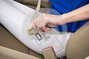 Woman hand fastening a seat belt in the car 1