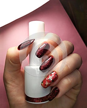 Woman hand finger black and red flower manicure gel nail polish swatch design white bottle beauty fashion photo