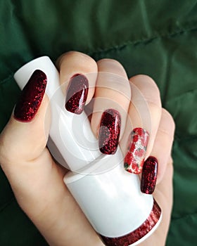 Woman hand finger black and red flower manicure gel nail polish swatch design white bottle beauty fashion photo