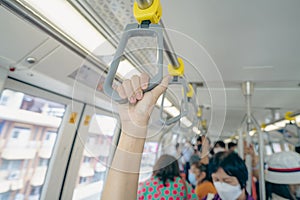 Woman hand firm grip safety handrail in elevated monorail train. Mass transit system in modern city. Inside of electric train.