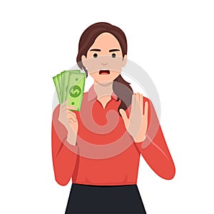 Woman with hand gesturing no or stop while holding money. No gamble or wrong investment
