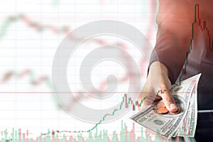 Woman hand giving dollar cash on stock trading graph background