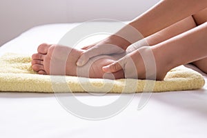 Woman hand giving massage to her foots in bedroom