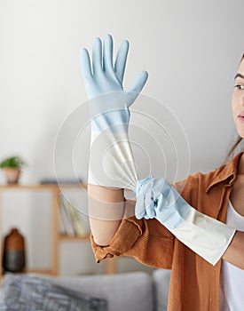 Woman, hand gloves and prepare to start cleaning, hygiene and housework in clean service, work and job in house. Female