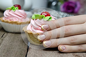 Woman hand with gold french manicure.