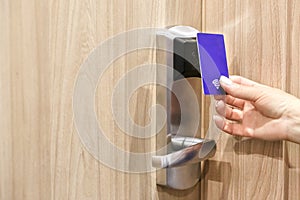 Woman hand hold card for door access control scanning key card to lock and unlock door