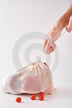 Woman hand hold fresh organic vegetables in textile bag. Zero waste and shopping concept