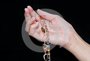 hand hold jewelry bracelet on black background