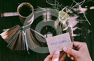 Woman hand hold a piece of paper with STAY HOME message in epidemic season by corona virus, work at home in social quarantine