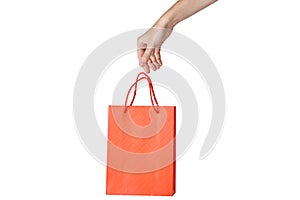 Woman hand hold red empty blank craft paper shopping bag isolated on white background. Packaging template mockup