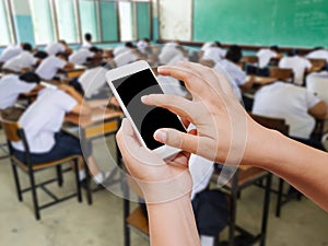 Woman hand hold and touch screen smart phone on students sleeping in class background.
