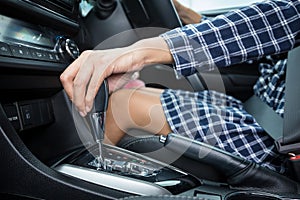 Woman hand holding automatic gear shift in a car