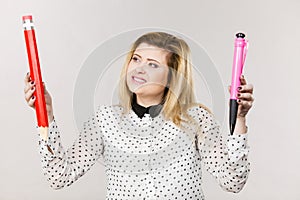Woman holding big pencil and pen