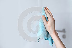 Woman hand holding a blue microfiber cleaning cloth