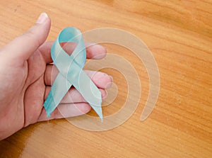 Woman hand holding blue ribbon, blue november conceot