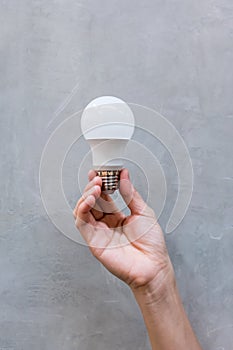 Woman hand holding brand new white LED light bulb