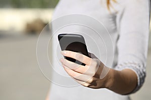 Woman hand holding and browsing a smart phone outdoor photo