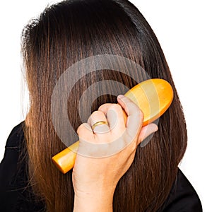 Woman hand holding brush combing hair.