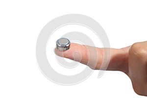 Woman hand holding a button battery with the forefinger photo