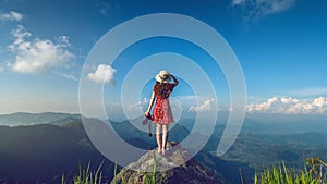 Woman hand holding camera and standing on top of the rock in nature. Travel concept. Vintage tone