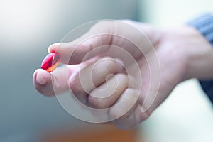 Woman hand holding capsule pills with pharmacy background