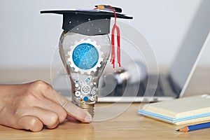 Woman hand holding cog inside in light bulb with graduates hat on natural green background, Education and Creative idea and innova