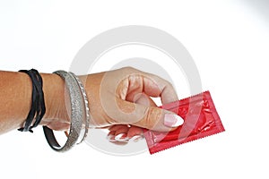 Woman hand holding condom on isolated white cutout background. Studio photo can illustrate hpv std gonorrhea, chlamydia