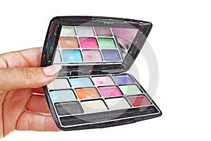 Woman hand holding cosmetic eyeshadow makeup palette on isolated white cutout background. Studio photo with studio