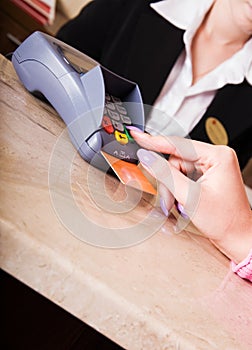 Woman hand holding credit card in payment terminal