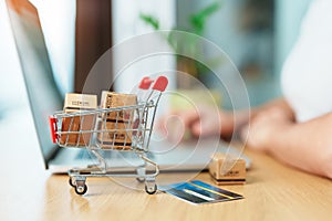 woman hand holding credit card and using laptop with mobile phone for online shopping while making order. Marketplace platform