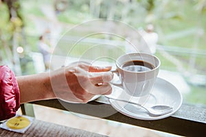 Woman hand holding a cup of hot Luwak coffee.