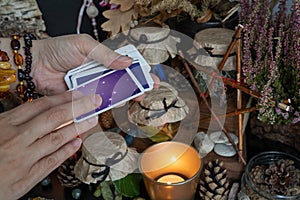 Woman hand is holding deck of tarot or oracle cards doing fortunetelling.