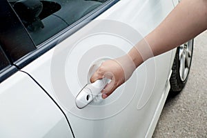 Woman hand holding door car to unlock or lock