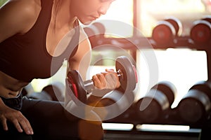 Woman hand holding dumbbell exercise in gym. Fitness muscular body with set of black weights