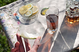 Woman hand holding eaten melon slice and ice tea sunset