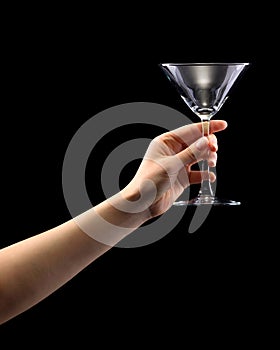 Woman hand holding empty martini glass isolated on black.