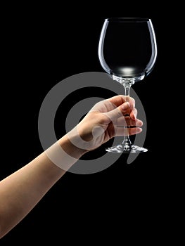 Woman hand holding empty wine glass isolated on black