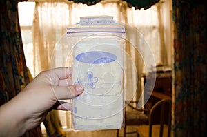 Woman hand holding frozen breast milk in storage bags
