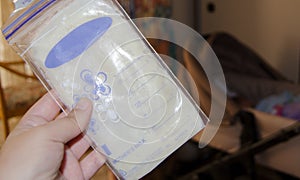 Woman hand holding frozen breast milk in storage bags