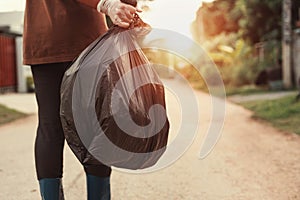 woman hand holding garbage bag for recycle putting in to trash