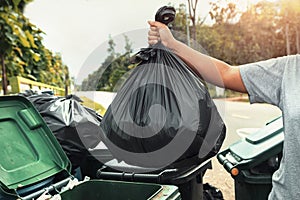 woman hand holding garbage in black bag for cleaning in to trash