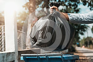 woman hand holding garbage bag put in to trash photo