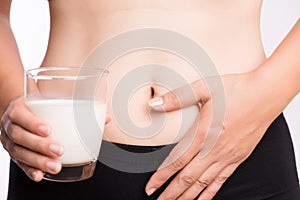 Woman hand holding glass of milk having bad stomach ache because of Lactose intolerance. health problem with dairy food products,
