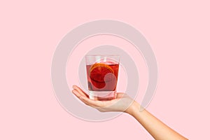 Woman hand holding a glass of red vermouth