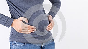 Woman hand holding her own belly fat and cellulite on white background. Women before weight loss and shape up healthy stomach